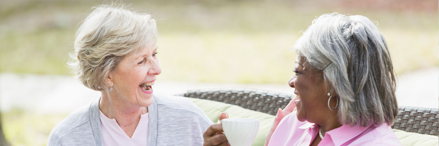 two elderly women talking and smiling