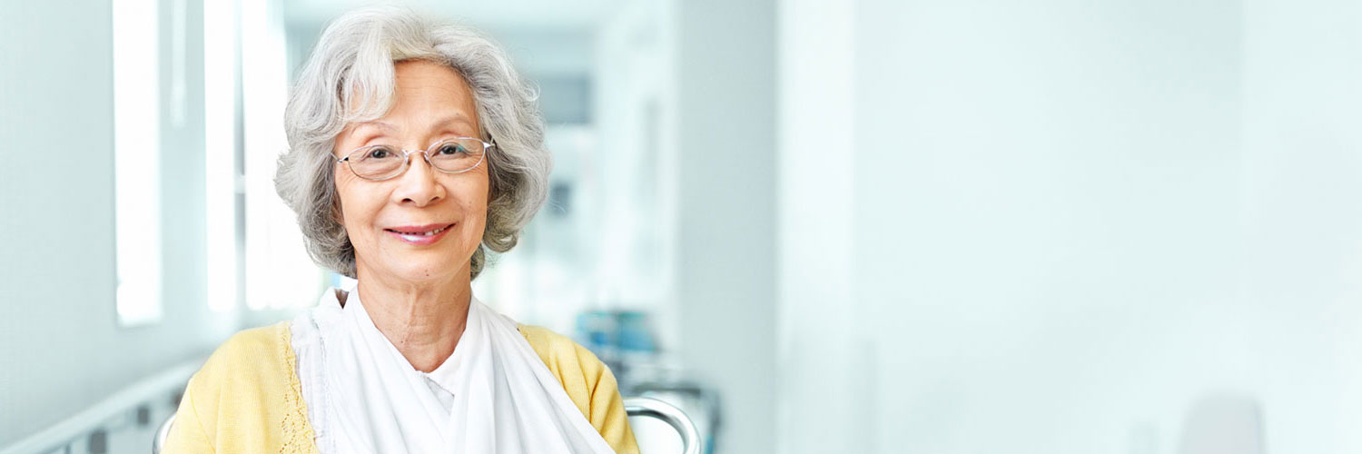 elderly woman wearing a sling smiling at the camera